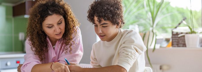 Mother helping her son with homework at home